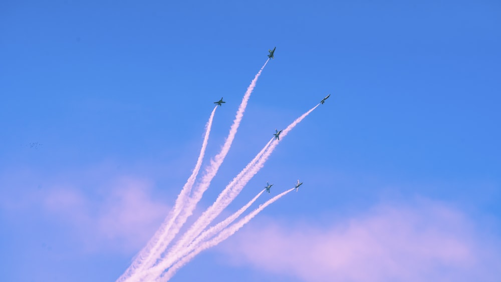 a group of jets flying through a blue sky