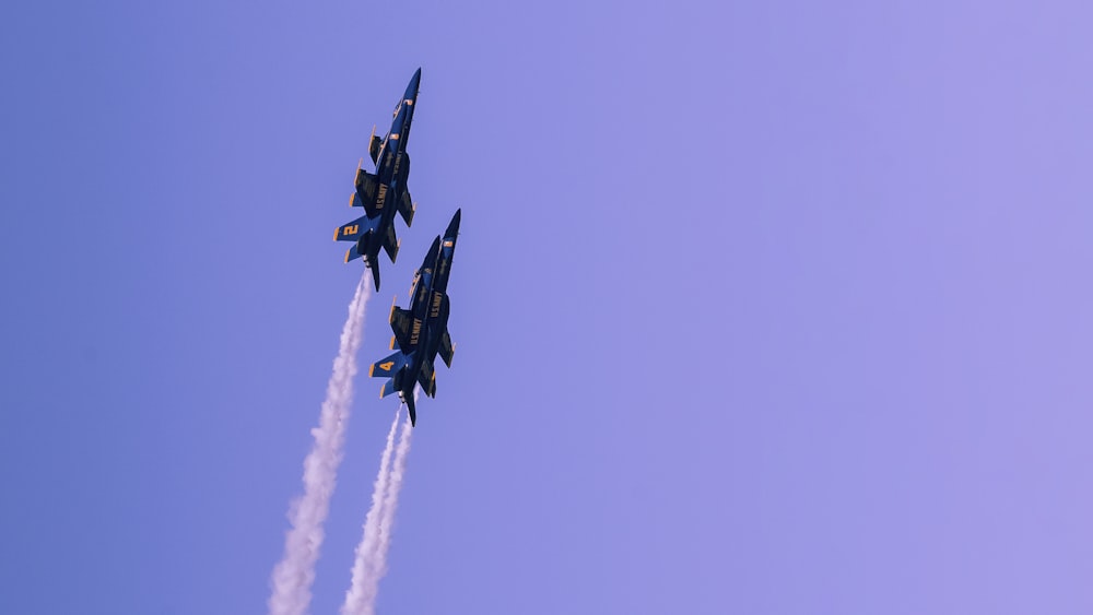 a group of fighter jets flying through a blue sky