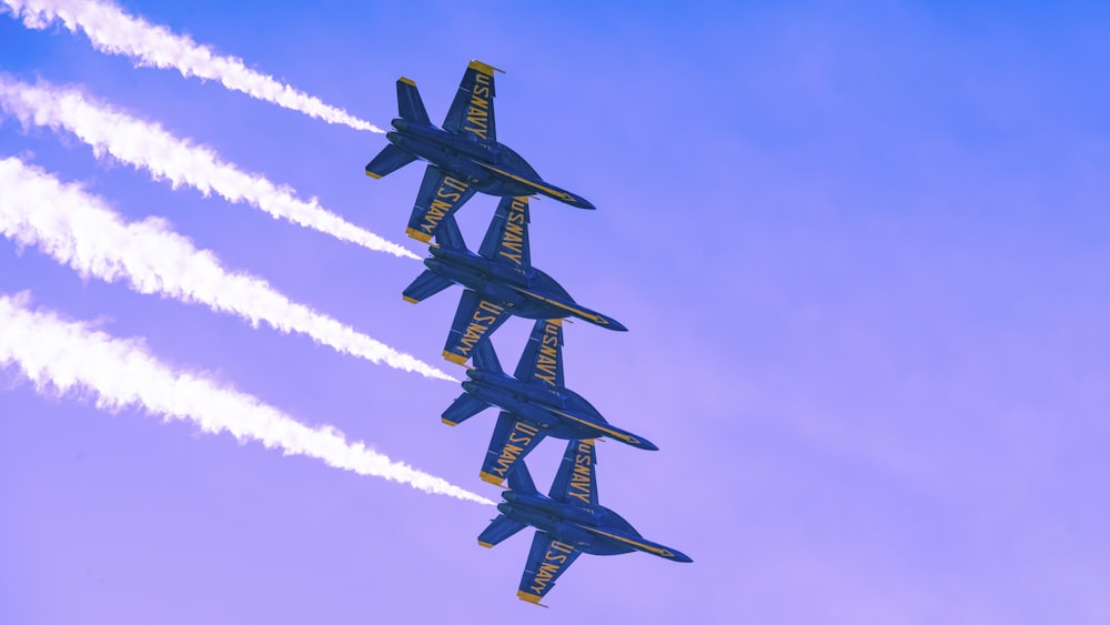 a group of fighter jets flying through a blue sky