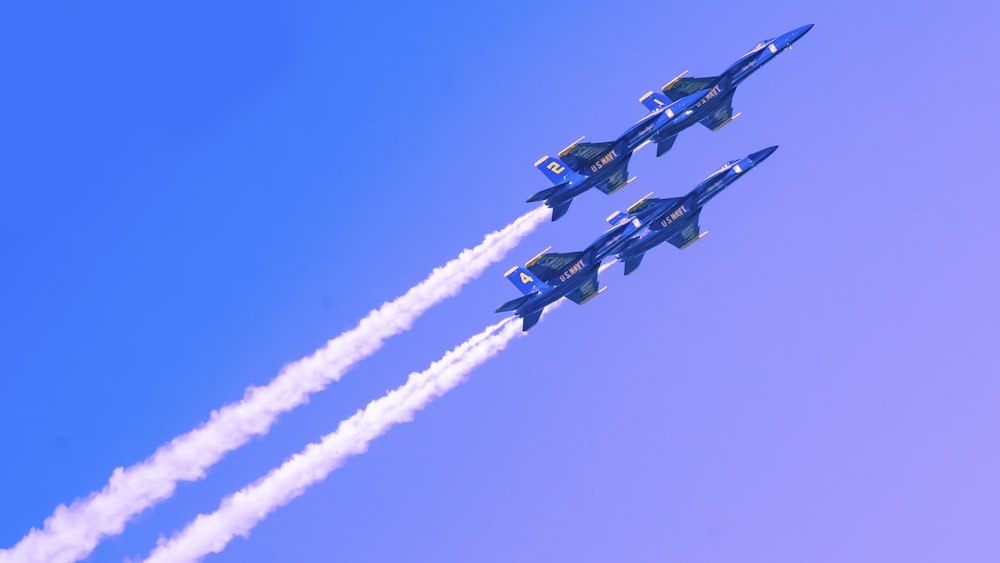 a group of fighter jets flying through a blue sky