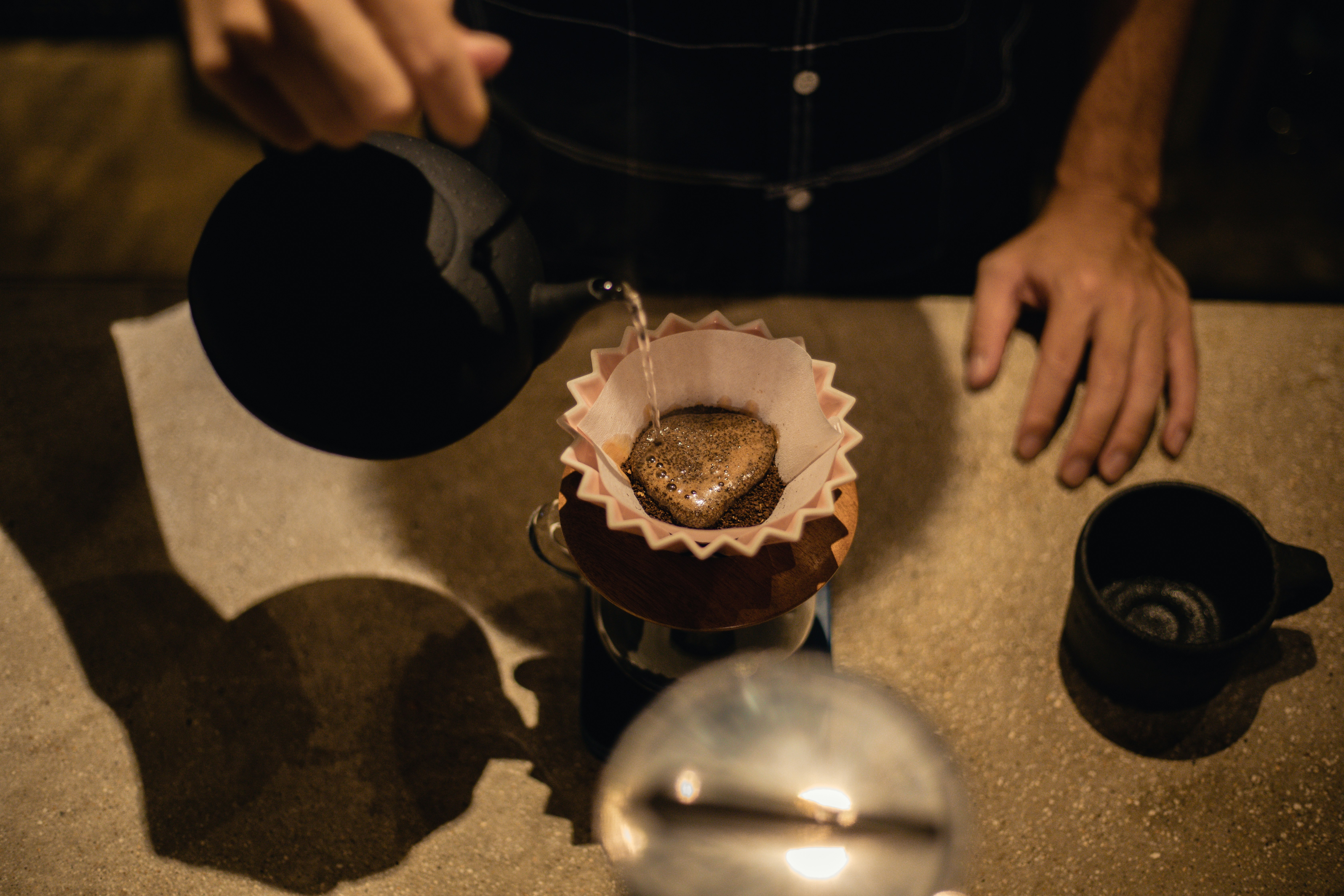 人がコーヒーをカップに注ぐ