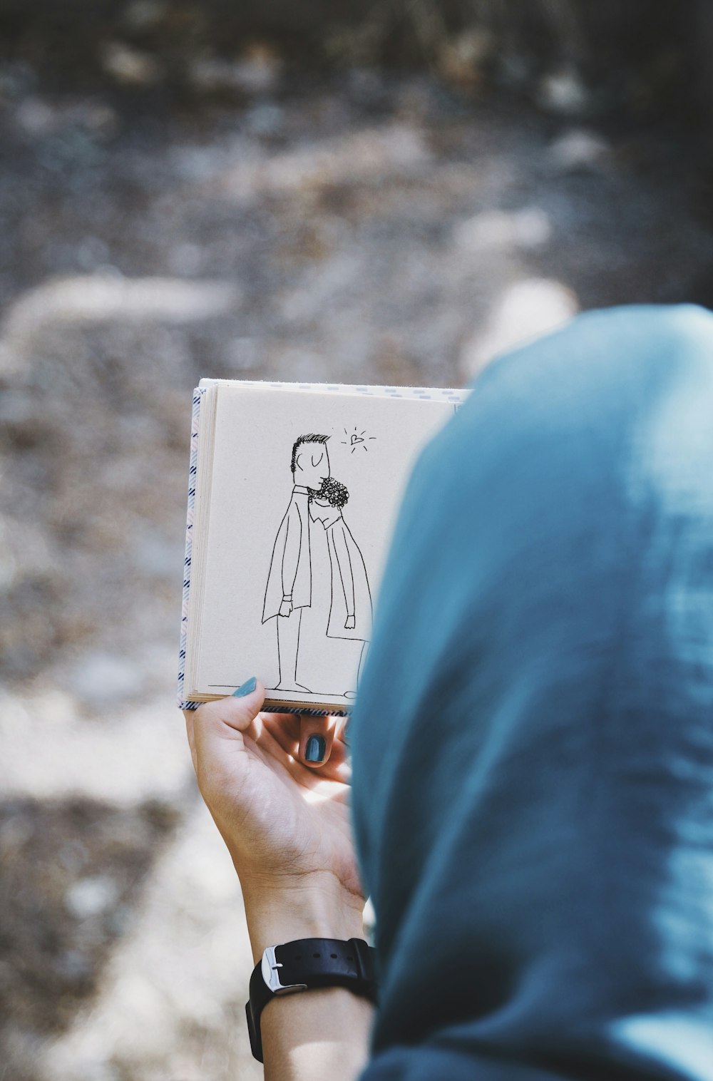 a person holding a book with a drawing of a man on it