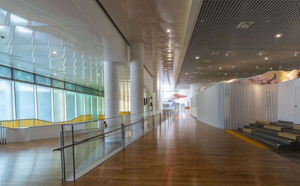 a long hallway with wooden floors and railings