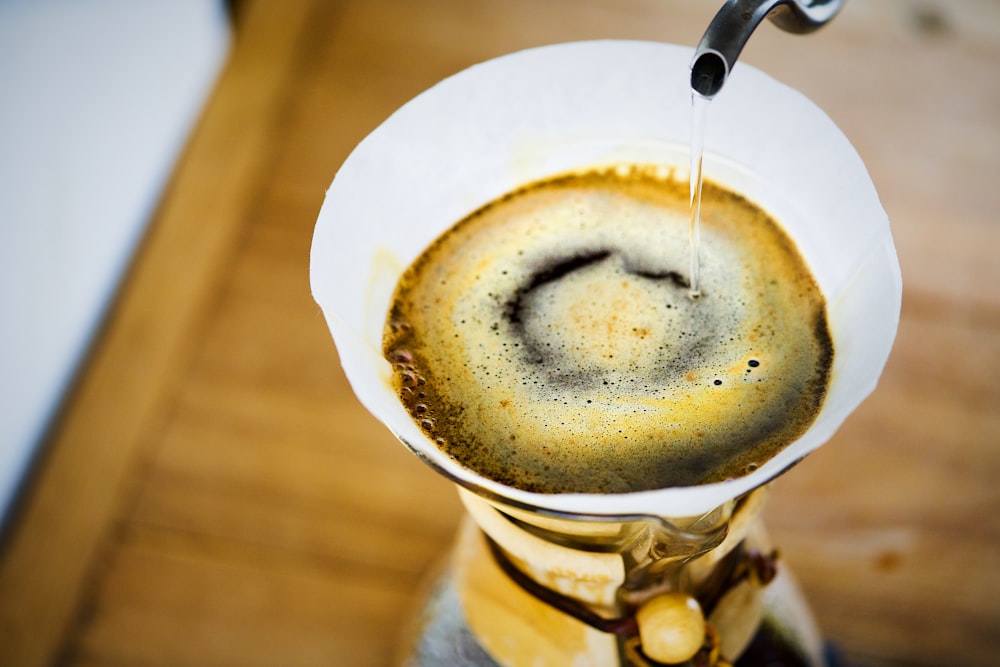 a cup of coffee is being filled with liquid