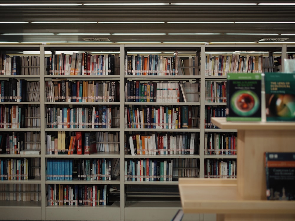 a bookshelf filled with lots of books in a library