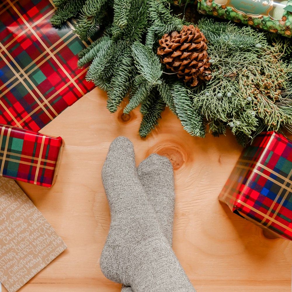 Die Füße einer Person mit Socken und Weihnachtsgeschenken