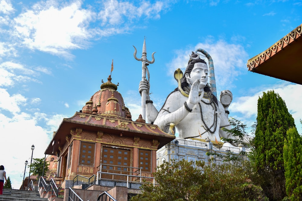 a statue of a god on top of a building