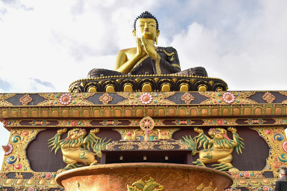 a statue of a buddha sitting on top of a fountain