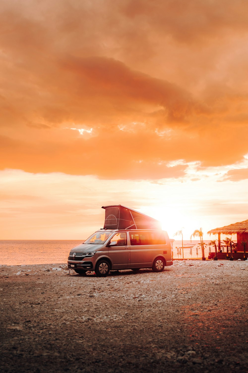 a van parked on the beach at sunset