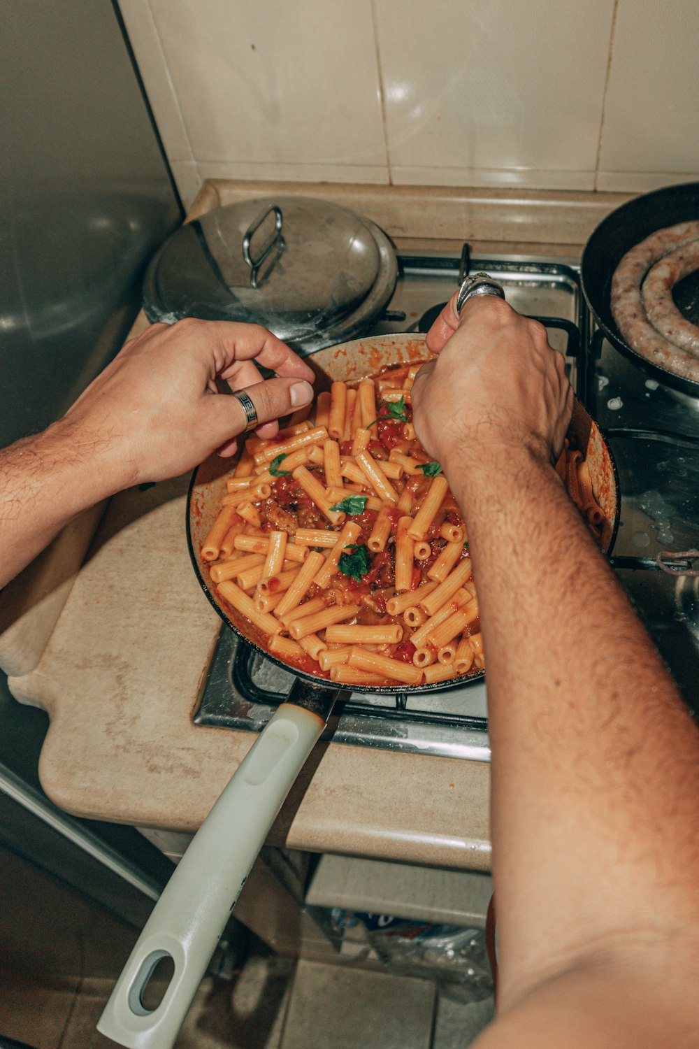 a man cooking pasta in a pan on the stove