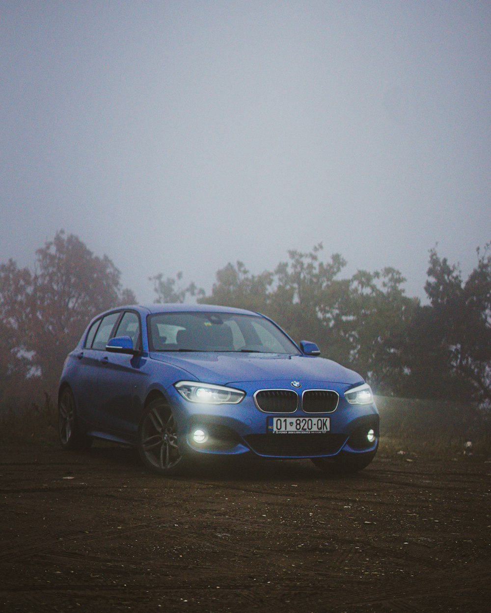 a blue car parked on a dirt road