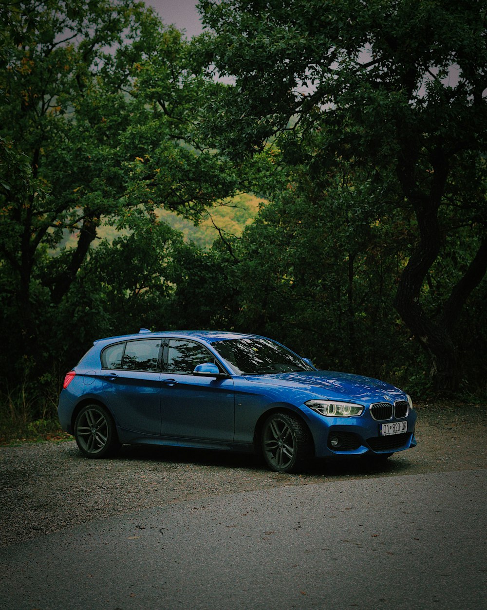 a blue car parked on the side of a road