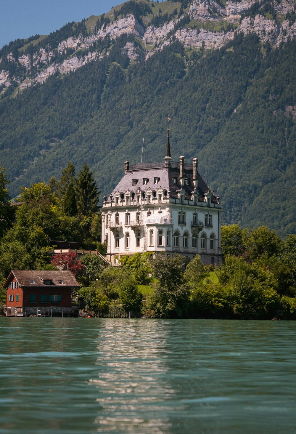 a large white building sitting on top of a lush green hillside