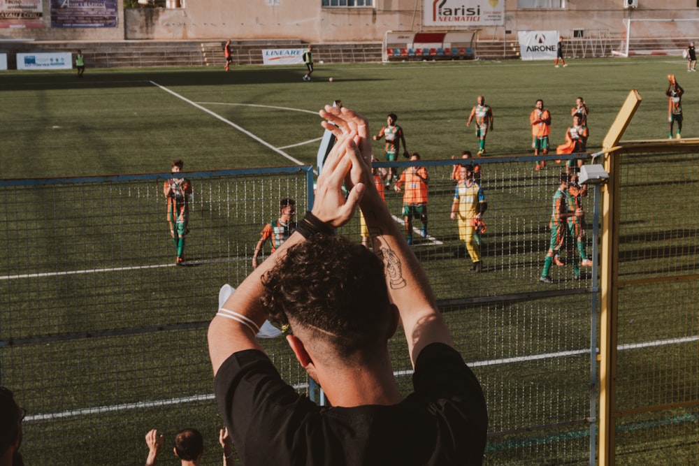 a group of people standing on top of a soccer field