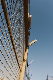 A professional installing a metal fence along a residential driveway.