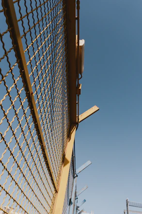Modern fence mesh installed around a residential garden under a clear blue sky.