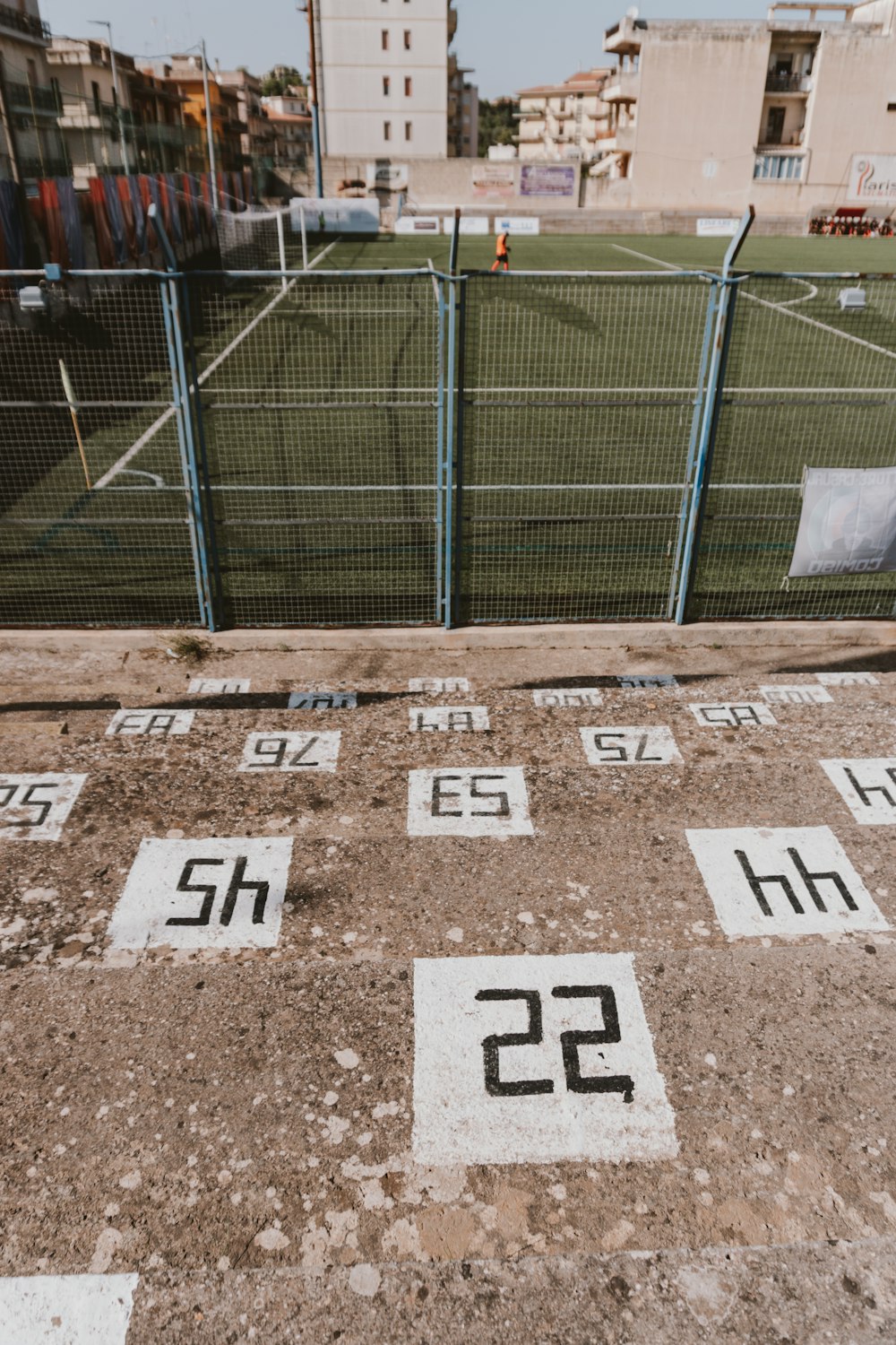 a field with numbers on it and a fence in the background