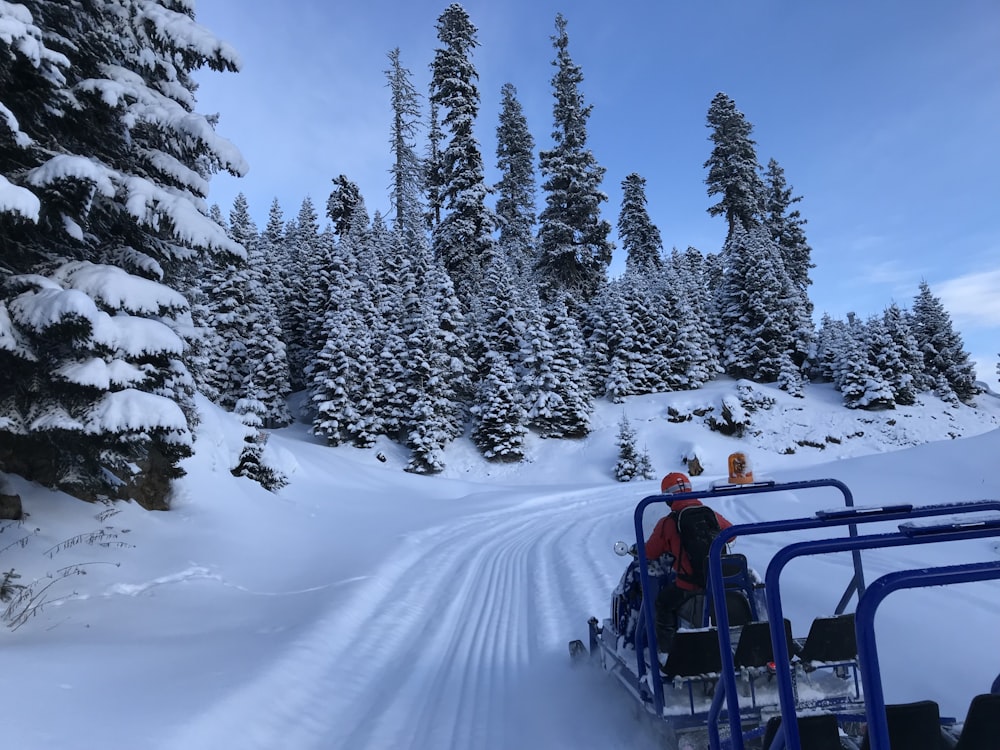 a group of people riding a snowmobile down a snow covered road