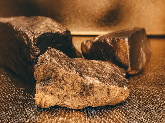 Rock samples on a table, representing the crude material that enters refineries as dore bars before emerging as investment-grade gold
