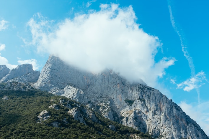 a very tall mountain with some clouds in the sky