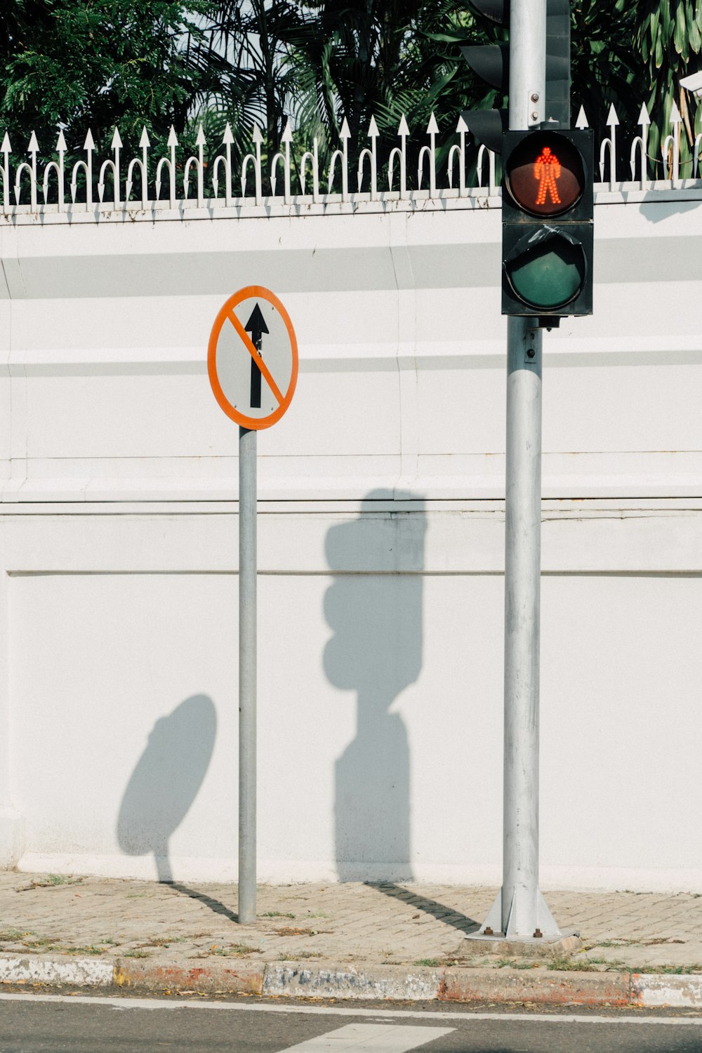 a traffic light sitting next to a white wall