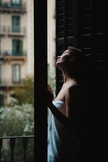 A peaceful moment showing a woman wrapped in a plush towel, her skin glowing softly in natural light.