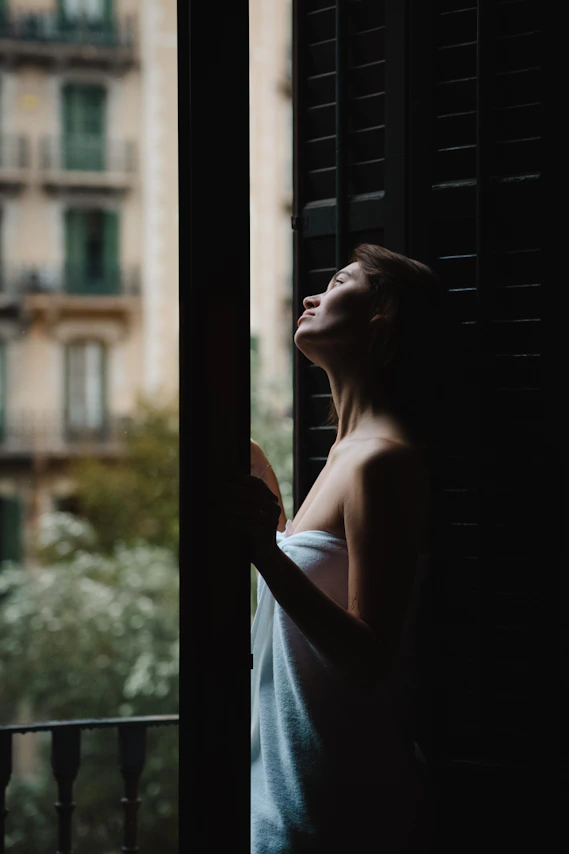a woman is looking out of a window