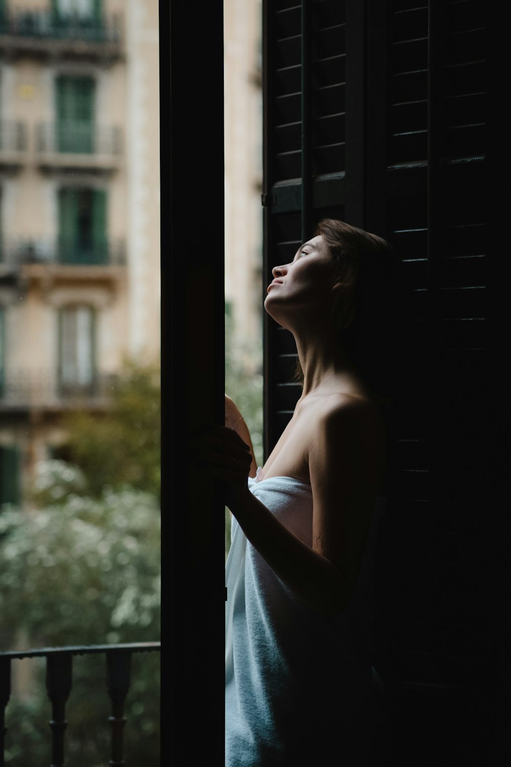 Una mujer está mirando por una ventana