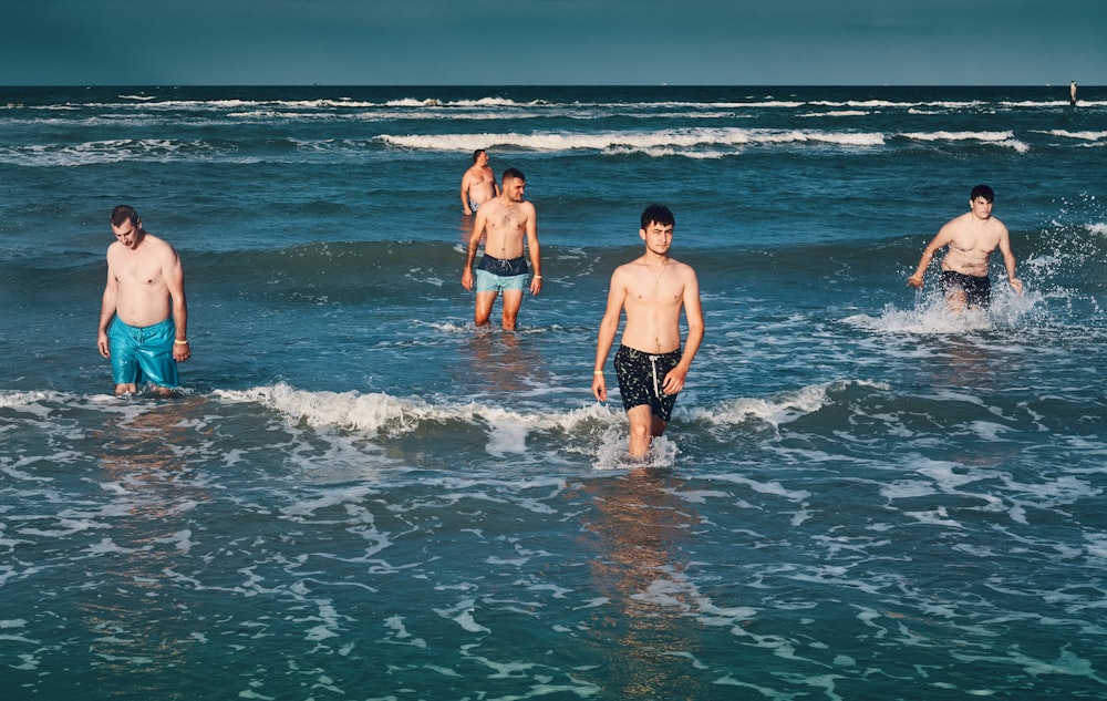 a group of men walking into the ocean