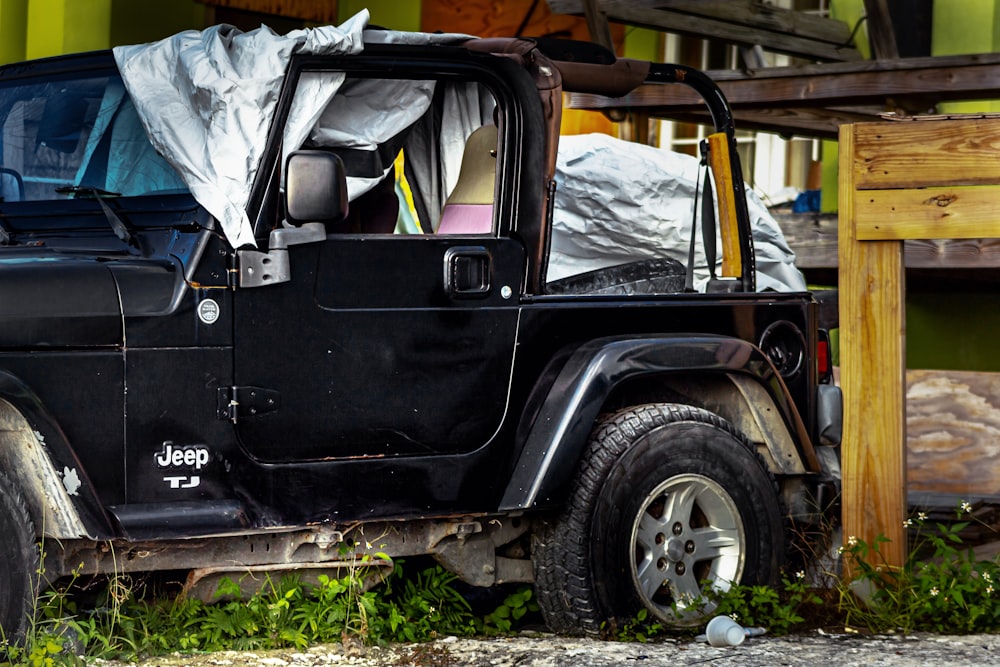 a black jeep with a tarp on top of it