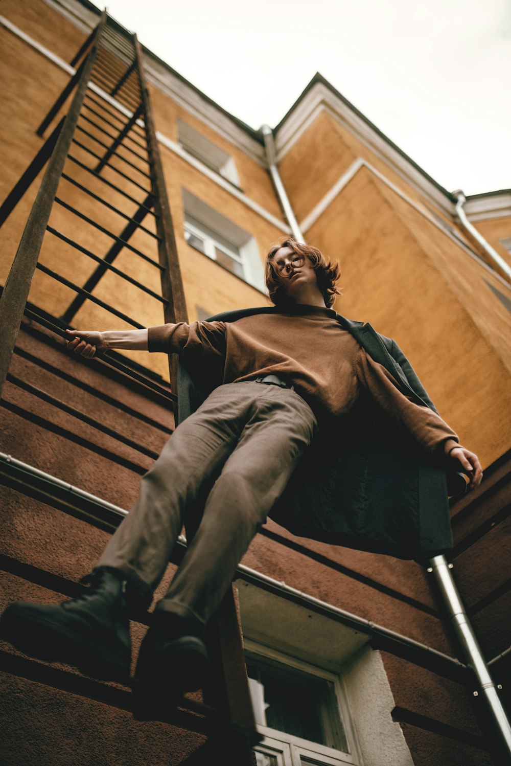 Ein Mann sitzt auf einer Leiter vor einem Gebäude