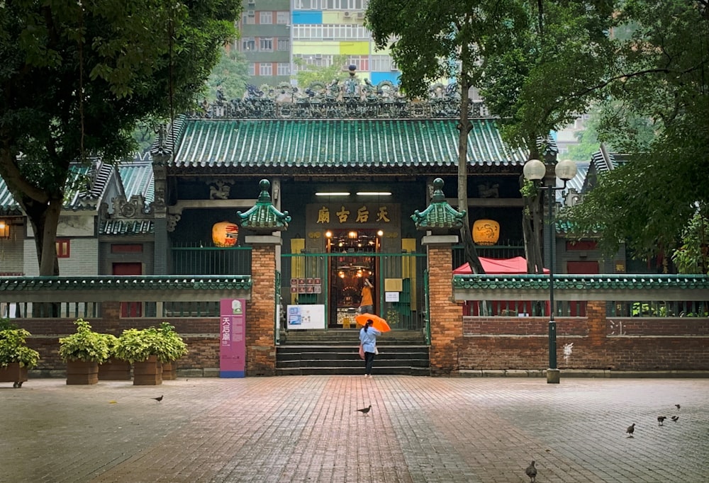 a person holding an umbrella in front of a building