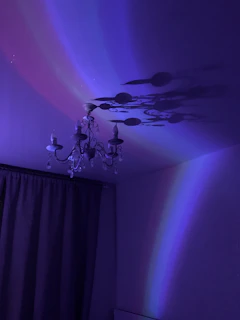 A sparkling chandelier casting colorful reflections against a dark ceiling, reminiscent of early 2000's glitter aesthetics.