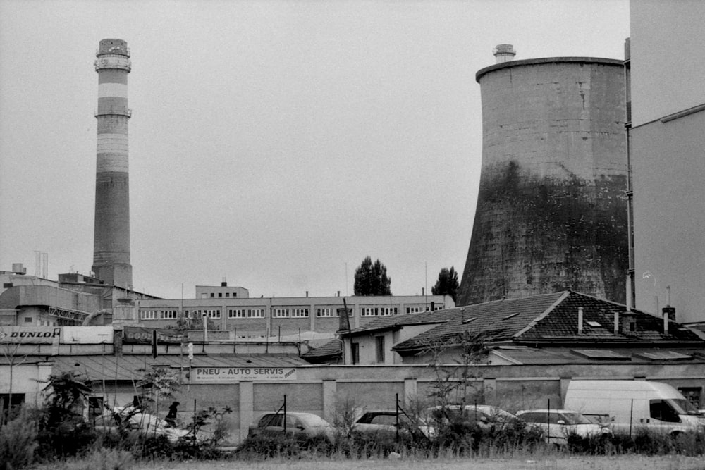 a black and white photo of a factory with smoke stacks