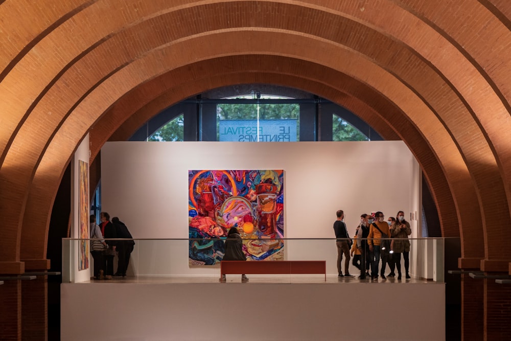 a group of people standing in front of a painting