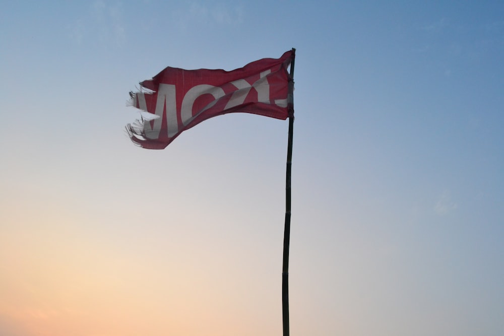 a red and white flag flying in the sky