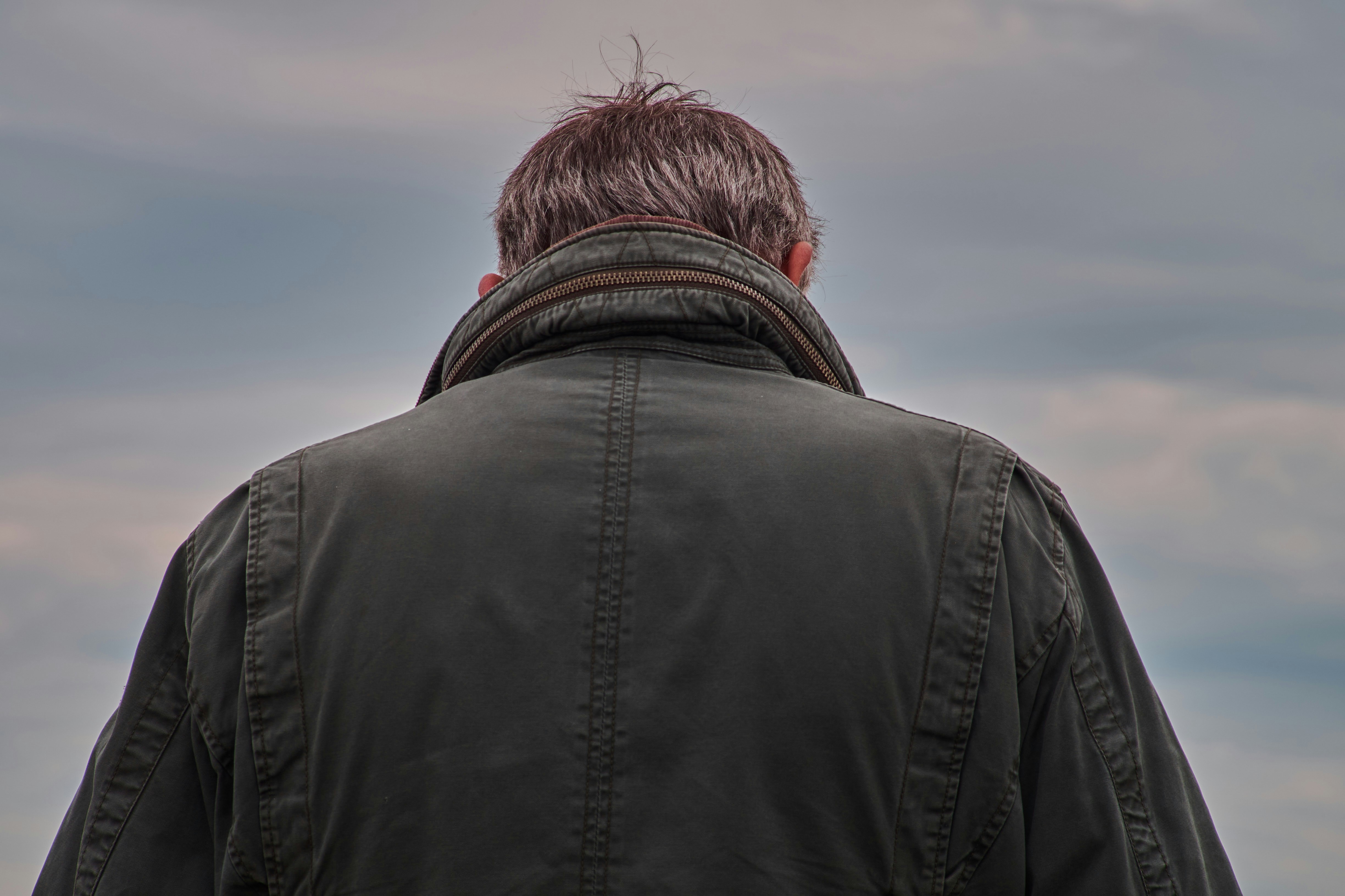 Un uomo in piedi di fronte a un cielo nuvoloso