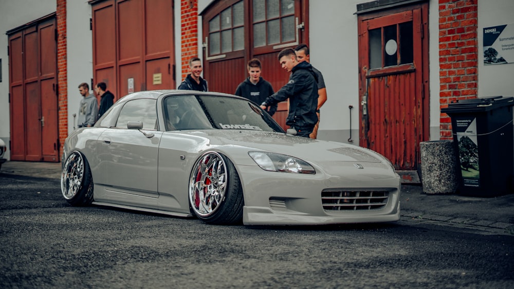 a silver sports car parked in front of a building