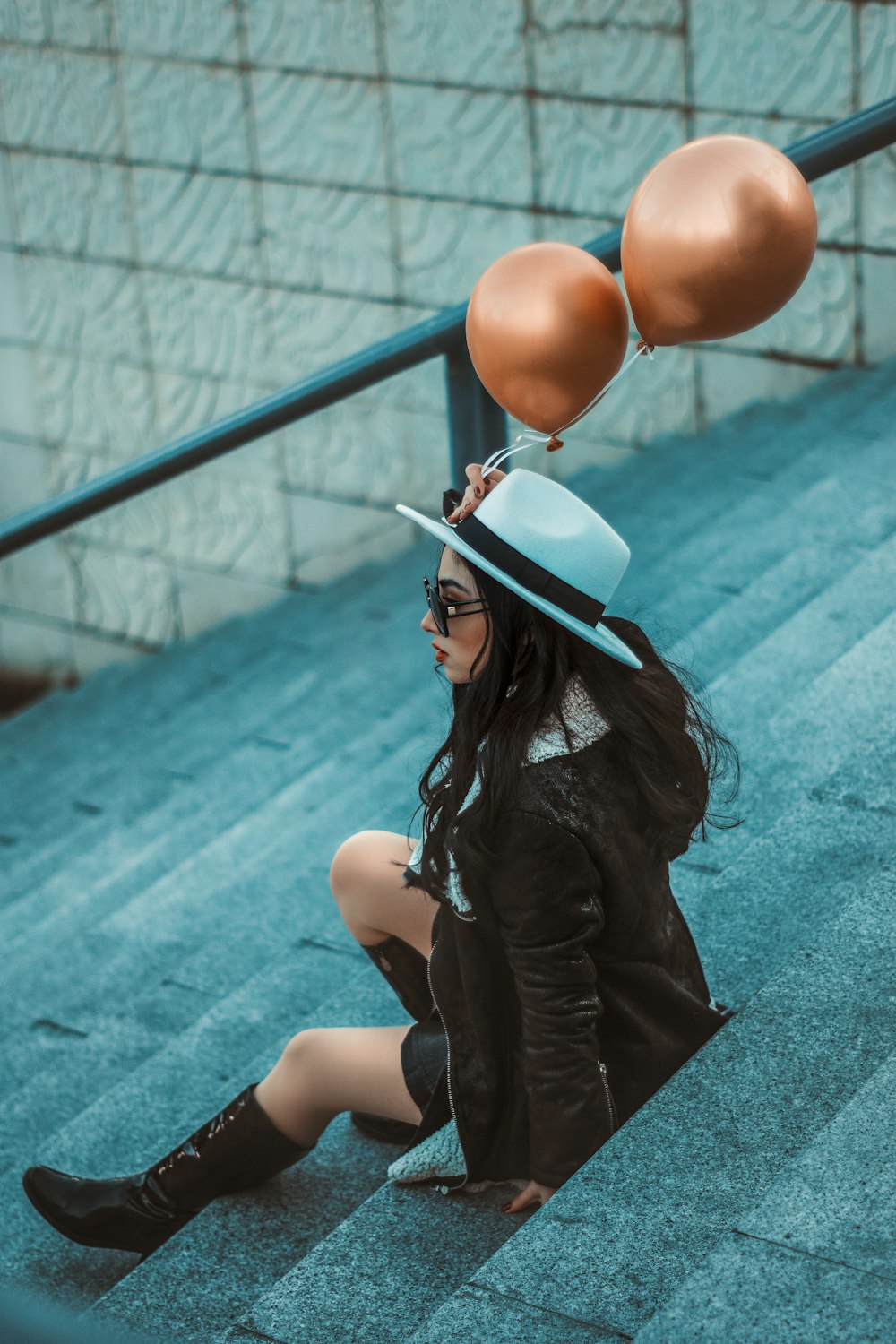 a woman sitting on the ground with balloons on her head