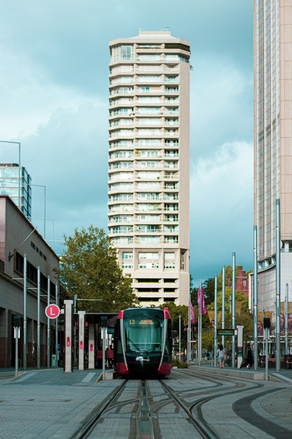 a train on a track in front of a tall building