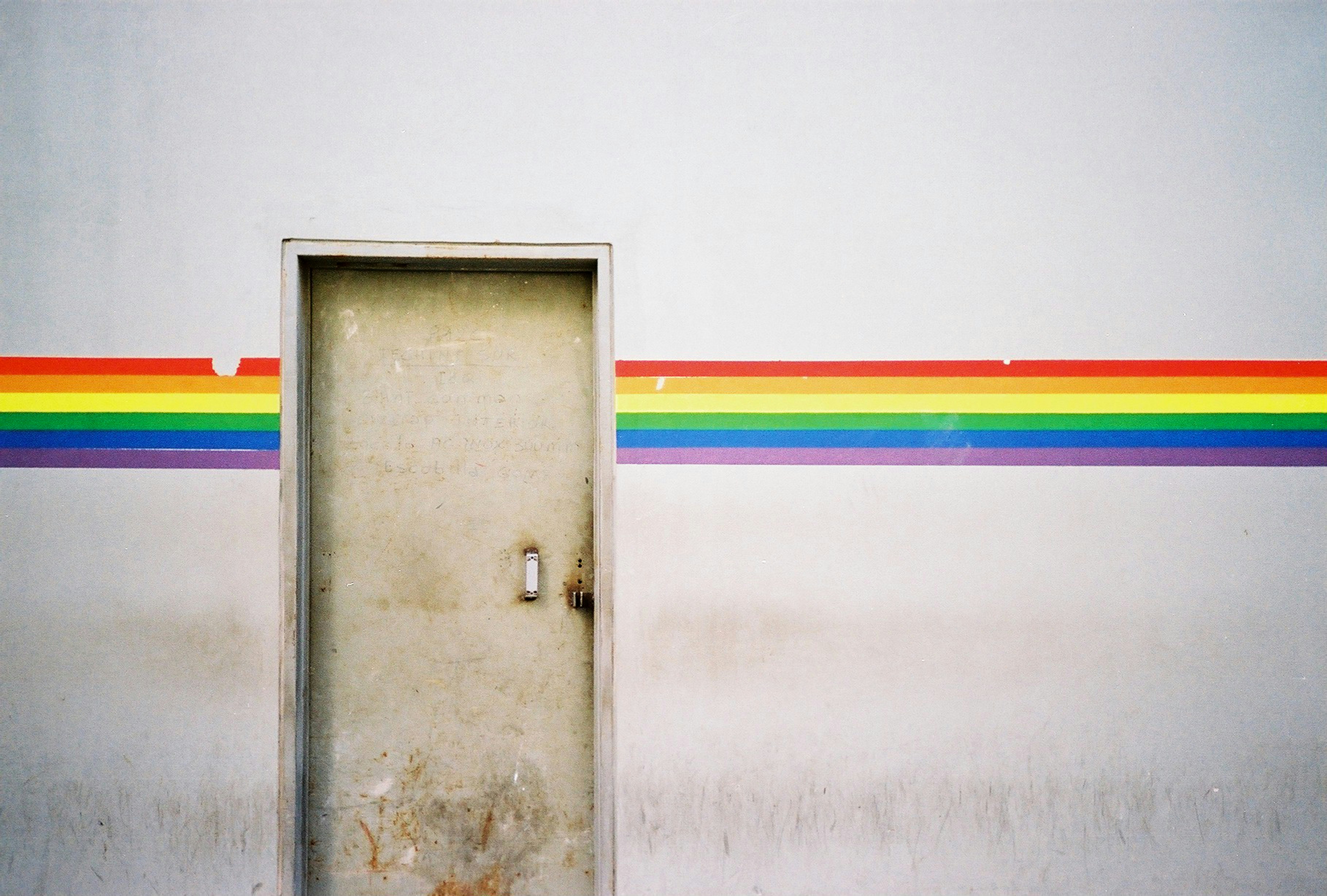 une porte avec un arc-en-ciel peint sur le côté