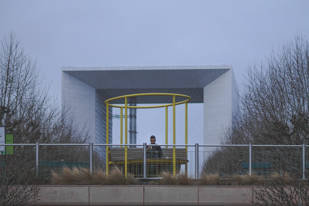 a person sitting on a bench in front of a building