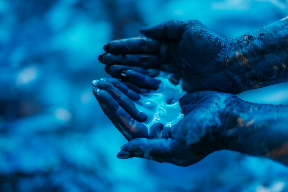 a pair of hands that are covered in blue paint