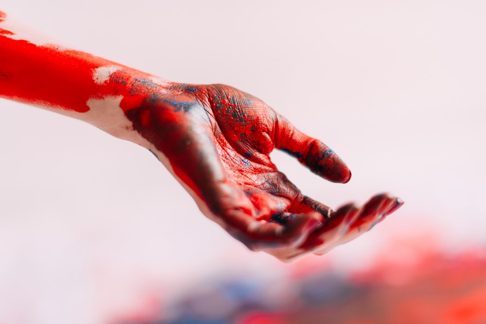 a person's hand with red and white paint on it