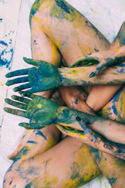 a woman covered in yellow and green paint