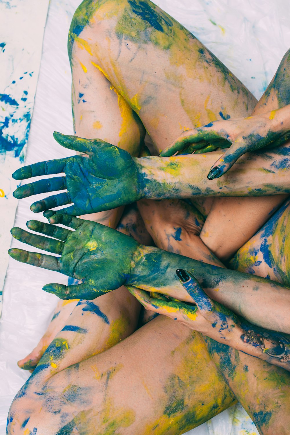 Una mujer cubierta de pintura amarilla y verde