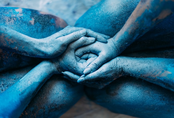 a person covered in blue powder holding their hands together