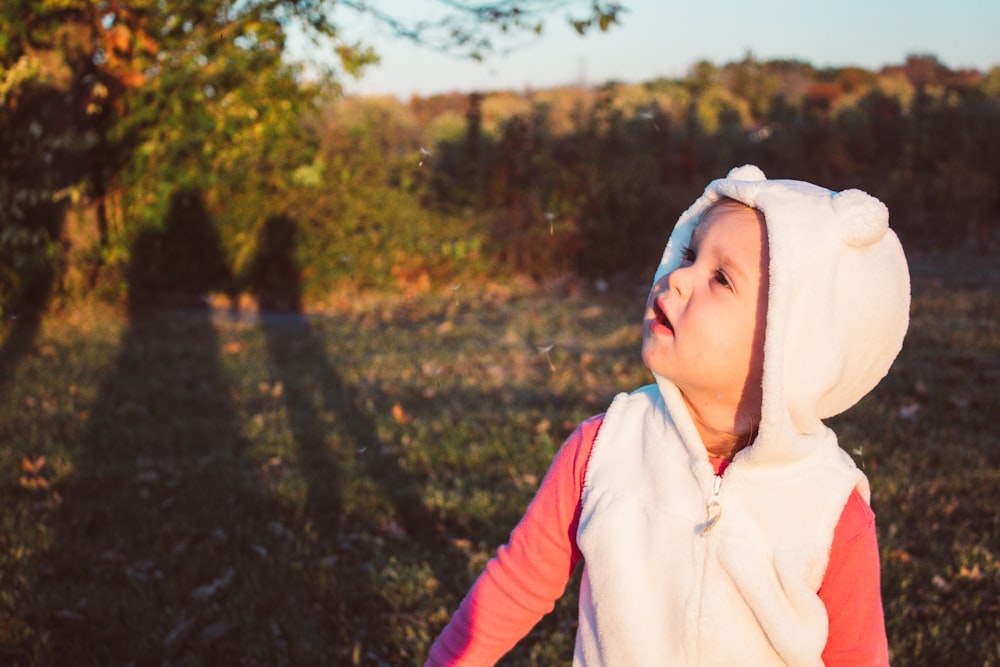 a little girl in a bunny costume standing in a field