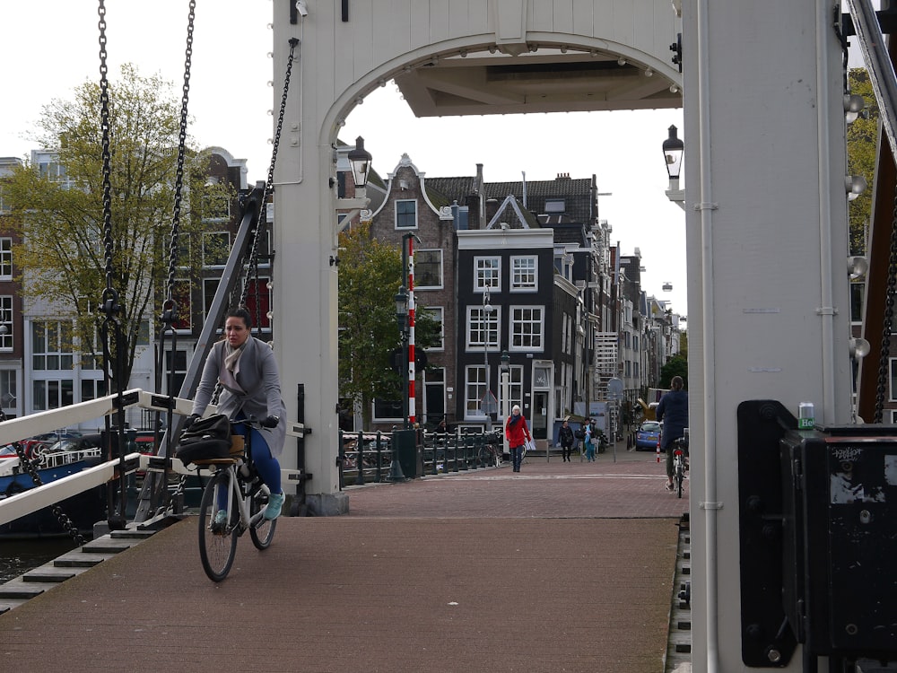 a man riding a bike across a bridge