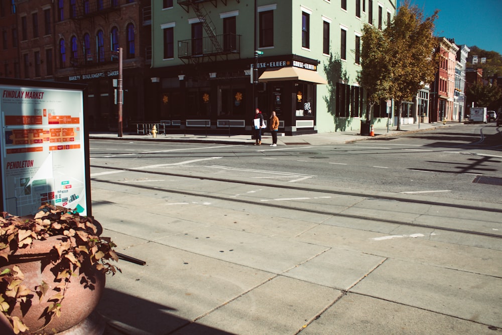 a street corner with a sign and a potted plant